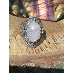 Bague en quartz rose monture en argent 925 posée sur du bois, lumière naturelle aux nuances pastel, ambiance douce et apaisante évoquant amour, tendresse et harmonie du cœur