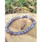 Bracelet tourmaline rose sur eudialyte sur tranche de bois avec fond végétal, écoute intérieure et tendresse émotionnelle