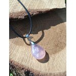 Pendentif goutte en quartz rose sur bois en lumière naturelle, collier pierre naturelle associé au réconfort, au calme des pensées et à l’apaisement émotionnel.