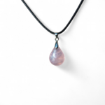 Pendentif goutte en quartz rose sur fond blanc, collier en pierre naturelle relié à l’amour de soi, à la douceur émotionnelle et au réconfort intérieur.