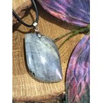 Pendentif labradorite avec bélière en acier inoxydable sur fond bois, pierre naturelle associée à la stabilité émotionnelle, au recentrage et à la présence à soi.