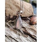 Pendentif labradorite violette sur bois texturé en ambiance bord d’eau, bijou en argent 925 associé à la lucidité, à la protection subtile et au recentrage.