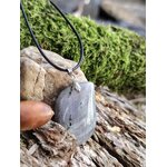 Pendentif labradorite sur cordon noir, posé sur écorce et mousse, bijou en pierre naturelle associé à la protection, à l’intuition et à l’enracinement intérieur.