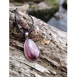 Pendentif lépidolite en argent 925 posé sur bois flotté en bord de mer, bijou en pierre naturelle associé à la sérénité, au lâcher-prise et à l’harmonie émotionnelle.