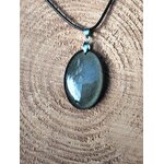 Pendentif obsidienne dorée sur fond bois clair, pierre naturelle évoquant la stabilité, la maîtrise de soi et une énergie plus posée.