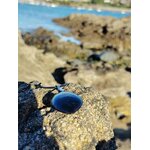 Pendentif tourmaline noire marquise posé sur rocher face à l’océan en Bretagne, pierre naturelle reliée à la protection, à la solidité émotionnelle et au recentrage.