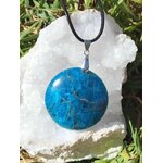Pendentif apatite bleue ronde sur un amas de quartz  en extérieur, bijou en pierre naturelle associé à la communication, à l’assurance et à l’élan intérieur.