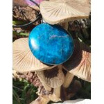 Pendentif apatite bleue sur champignon beige en décor nature, pierre naturelle évoquant la douceur émotionnelle, l’intuition sensible et le recentrage.