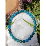 Bracelet en apatite bleue posé sur amas de quartz avec herbe, bijou lithothérapie pour relâcher la pression mentale et adoucir les émotions