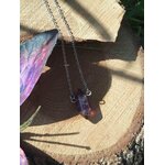 Pendentif améthyste en pointe sur chaîne fine, photo sur tranche de bois avec décor féerique, bijou lithothérapie évoquant la douceur du cœur, le lâcher-prise et la sagesse intérieure.