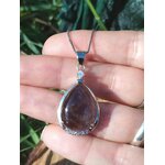 Pendentif goutte améthyste tenu dans la main, pierre naturelle violette pour calme intérieur et énergie sereine