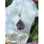 Pendentif goutte améthyste monté sur métal argenté, posé sur amas de quartz blanc en extérieur, paix intérieure et élévation douce