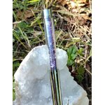 Stylo bille améthyste posé sur une géode de cristal dans l’herbe, accessoire d’écriture en pierres naturelles pour créativité, concentration et sérénité – boutique Magic Gaïa.
