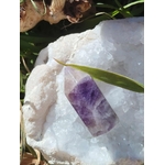 Pointe d’améthyste violette posée sur amas de quartz blanc en extérieur, pierre naturelle associée à l’élévation, à la clarté intérieure et au relâchement du mental.