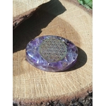 Petit galet énergétique en orgonite améthyste décoré d’une fleur de vie, présenté sur support en bois naturel, idéal pour apaiser l’ambiance, équilibrer les énergies et soutenir le bien-être spirituel