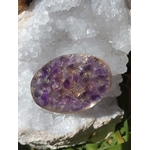 Petit galet en orgonite améthyste posé sur une grande géode de cristal blanc en extérieur, création énergétique pour soutenir le bien-être mental, émotionnel et spirituel et sublimer une décoration ésotérique