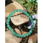 Bracelet aventurine verte 6 mm autour de champignons dans l’herbe, apaisement du mental, tendresse intérieure et énergie du cœur