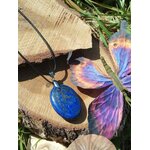 Pendentif lapis lazuli bleu sur support en bois avec papillon coloré, bijou naturel lié à l’inspiration, à l’aisance relationnelle et au calme du mental.