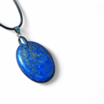 Pendentif lapis lazuli bleu sur fond blanc lumineux, pierre naturelle associée à la présence d’esprit, à la sérénité et à la vision intérieure.
