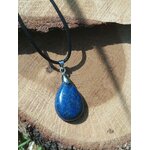 Pendentif goutte en lapis lazuli bleu sur rondin de bois, bijou Magic Gaïa en pierre naturelle associé à la maîtrise de soi, à la clarté mentale et à l’équilibre intérieur.