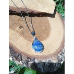 Collier avec pendentif goutte en lapis lazuli bleu posé sur rondin de bois, bijou en pierre naturelle associé à la maîtrise de soi, à la lucidité et à l’équilibre émotionnel.