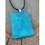Zoom sur pendentif en fluorite verte rectangulaire monté sur cordon noir, fond bois naturel, pierre naturelle associée au recul, à la fraîcheur mentale et à l’harmonie intérieure.