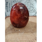 Forme libre Cornaline naturelle posée sur bois, pierre orange-rouge pour la lithothérapie – vitalité, créativité, confiance en soi.