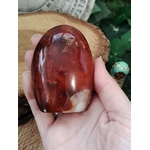 Forme libre Cornaline naturelle tenue dans la main, pierre orange-rouge pour la lithothérapie – vitalité, créativité, confiance en soi, chakra sacré
