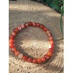 Bracelet cornaline posé sur bois, bijou en pierre orange pour focus mental, tonus intérieur et stabilité émotionnelle