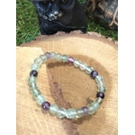 Bracelet fluorite verte et violette en pierres naturelles posé sur rondin de bois, bijou de lithothérapie Magic Gaïa pour clarté mentale et équilibre émotionnel.