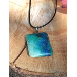 Pendentif azurite chrysocolle bleu vert sur tranche de bois, pierre naturelle liée à l’harmonie intérieure, au calme des pensées et à la parole posée.