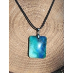 Pendentif azurite chrysocolle rectangulaire bleu vert sur cordon noir, présenté sur rondin de bois, pierre naturelle reliée au discernement, à la stabilité émotionnelle et à l’expression sincère.