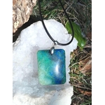 Pendentif azurite chrysocolle rectangulaire bleu vert sur cordon noir, posé sur géode en décor naturel, pierre naturelle associée au recentrage, à la sérénité et à l’expression apaisée.