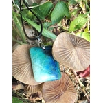 Pendentif azurite chrysocolle bleu vert rectangulaire sur cordon noir, posé parmi des champignons et feuilles en sous-bois, pierre naturelle évoquant la tranquillité, la présence à soi et la communication apaisée.