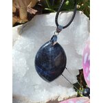 Pendentif sodalite bleue naturelle en forme de feuille sur cordon noir, posé sur amas de quartz, bijou en pierre naturelle associé au discernement, à l’intuition et à l’équilibre intérieur.