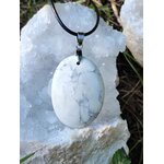 Pendentif howlite blanche sur cordon noir, posé sur amas de quartz en extérieur, calme du mental, détente nerveuse et douceur intérieure