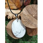 Pendentif howlite blanche posé contre des champignons décoratifs, relâchement du stress, calme intérieur et repos plus paisible