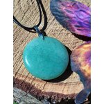 Pendentif aventurine verte sur cordon noir, posé sur tranche de bois avec papillon coloré, pierre naturelle pour équilibre émotionnel et douceur du cœur