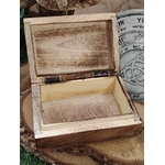 Boîte à bijoux en bois sculpté Gaïa ouverte, montrant l’intérieur en bois brut, posée sur un support naturel.