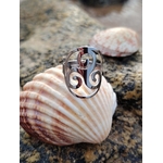Bague Triskell réglable en acier inoxydable, symbole celtique de protection et d’harmonie, posée sur un coquillage en bord de mer –en Bretagne  bijou ésotérique Magic Gaïa.