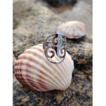 Bague Triskell réglable en acier inoxydable, bijou celtique de protection et d’harmonie posé sur un coquillage sur la plage en Bretagne