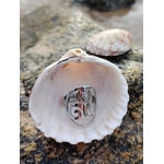 Bague Triskell réglable en acier inoxydable, symbole celtique de protection et d’harmonie, présentée dans un coquillage ouvert sur un rocher en bord de mer en Bretagne bijou Magic Gaïa