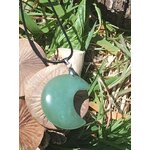 Pendentif lune en aventurine verte posé sur champignon et herbe, bijou en pierre naturelle évoquant la tranquillité, la patience et la douceur relationnelle.