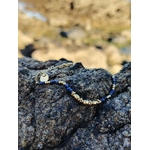 Bracelet lapis lazuli et acier inoxydable doré, bijou fin élégant sur pierre grise, photo en extérieur