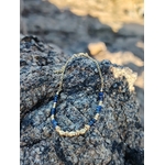 Bracelet perles lapis lazuli facettées et détails dorés, acier inoxydable résistant à l’eau, photo sur rocher