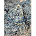 Vue complète bracelet fin femme lapis lazuli sur chaîne dorée, fermoir mousqueton, décor rocheux en Bretagne