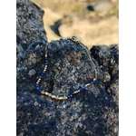 Bijou pierre naturelle bleue lapis lazuli sur chaîne fine dorée, photo lifestyle sur rocher au bord de mer en Bretagne