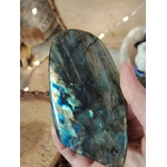 Labradorite forme libre tenue en main, reflets bleu-vert intenses et labradorescence visible, pierre naturelle liée au discernement, au recentrage et à l’équilibre intérieur.