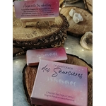 Le Petit Oracle des Sœurcières (L’Atelier des Sœurcières) : boîte rose et cartes oracle en français posées sur rondins de bois, avec pierres de quartz blanc et guirlande lumineuse – Magic Gaïa