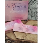 Carte “Augmente tes vibrations” du Petit Oracle des Sœurcières (L’Atelier des Sœurcières) : carte rose avec message inspiration, coffret en arrière-plan sur rondins de bois, décor mandala ésotérique